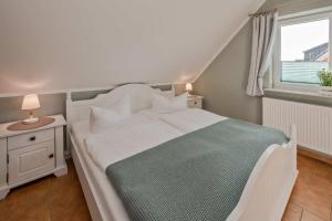 a bedroom with a white bed and a window at Ferienwohnung Thurbruch in Zirchow