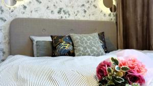 a bed with a bouquet of flowers on it at Apartament Słoneczny 31 in Czechowice-Dziedzice