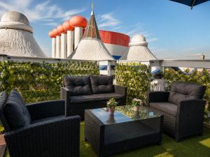 a patio with chairs and a table on a roof at Velocity boutique hotel in Zandvoort
