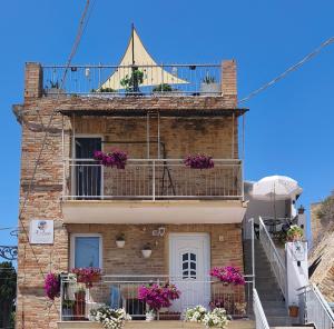 a brick building with a balcony with flowers on it at Il BORGO in Lapedona