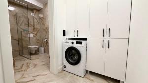 a white laundry room with a washing machine at DREAM HOUSE Apartaments in Bistriţa