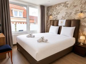 a bedroom with a bed with two teddy bears on it at Velocity boutique hotel in Zandvoort