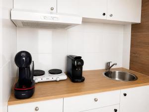 a kitchen counter with a coffee maker and a sink at Velocity boutique hotel in Zandvoort