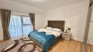 a bedroom with a bed and a large window at DREAM HOUSE Apartaments in Bistriţa