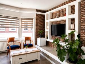 a living room with a tv and a brick wall at Velocity boutique hotel in Zandvoort