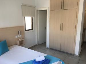 a bedroom with a bed and a closet and a door at Mandali Court in Ayia Napa