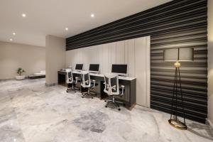 a conference room with a row of desks and chairs at Garden Melenium - Jeddah in Jeddah