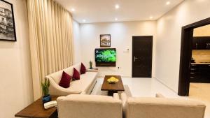a living room with a couch and a tv at Dome El Nozha in Riyadh