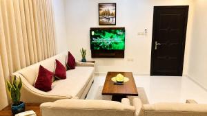 a living room with a couch and a tv at Dome El Nozha in Riyadh +37 photos
