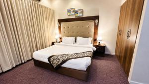 a hotel room with a large bed with white sheets at Dome El Nozha in Riyadh
