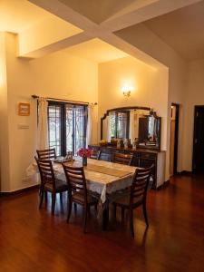a dining room with a wooden table and chairs at Ivy Hill in Yedapalli