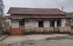 a small white house with a fence in front of it at Aconchego Central in Tiradentes