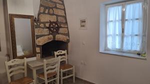 a dining room with a table and a fireplace at Cavo Paradise Studio Cyclades in Kimolos