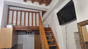 a wooden staircase in a room with a television at Cavo Paradise Studio Cyclades in Kimolos +6 photos