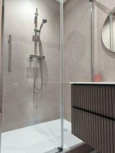a shower with a glass door in a bathroom at Chambre d'hôte in Maligny