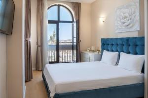 a bedroom with a large bed with a large window at Next Apartments Constanta in Constanţa