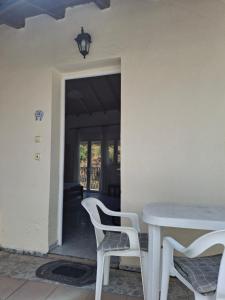 a white table and chairs in a room at Studios Elena Central in Limenaria
