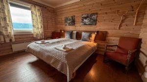 a bedroom with a bed and a chair and a window at Terråk Gjestegård in Terråk