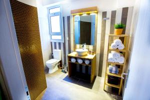 ein Badezimmer mit Waschbecken, Toilette und Spiegel in der Unterkunft Emerald Suite in Athen + 27 Fotos