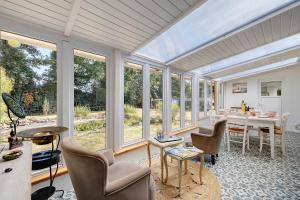 a living room with a table and chairs and windows at Maison d'hôtes Au Cocon de Verdure in Châteauneuf