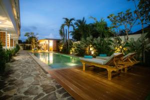 a swimming pool with a bench next to a house at JeKa Escotel & Loft in Seminyak +14 photos