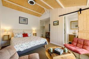 a bedroom with a bed and a couch and a table at Maison d'hôtes Au Cocon de Verdure in Châteauneuf