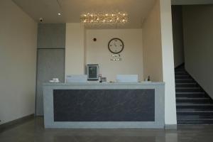 a lobby with a counter and a clock on the wall at Hotel Tavijay in Jhunjhunūn