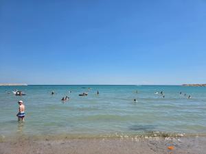 a group of people in the water at the beach at Villa Violand in Limanu
