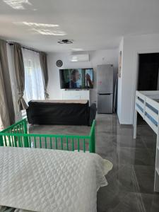 a living room with a bed and a kitchen at Villa Violand in Limanu