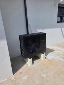 a black tv sitting on the side of a building at Villa Violand in Limanu