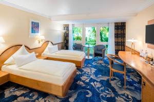 a hotel room with two beds and a desk at Hotel Asemann Planegg in Planegg +51 photos