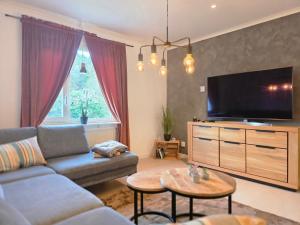 a living room with a couch and a flat screen tv at Villa Älvskogen in Vidsel
