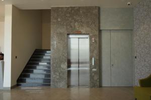 a metal elevator in a building with a staircase at Hotel Tavijay in Jhunjhunūn
