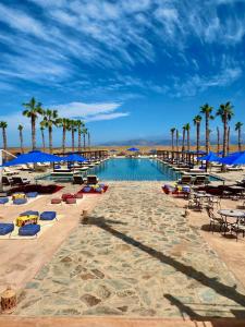 a resort with palm trees and a swimming pool at Agafay Oryx Camp in Aït Mazou