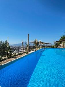 a large swimming pool with a clear blue sky at Villa Palmentiello - Villa con piscina e Vista Golfo di Napoli & Vesuvio in SantʼAntonio Abate