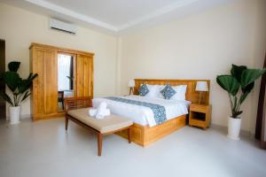 a bedroom with a bed and a chair and a table at JeKa Escotel & Loft in Seminyak