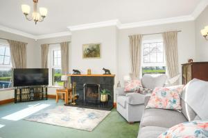 a living room with a fireplace and a television at Turner's Corner by Escape Ordinary in Aghadowey