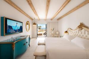 a bedroom with a white bed and a blue cabinet at Mitsis Selection Laguna in Hersonissos