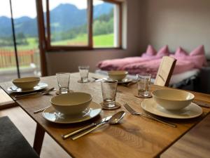 a wooden table with bowls and plates and silverware at Haus Casimir in Reith im Alpbachtal