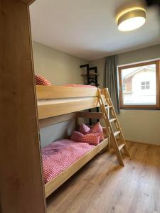 a bunk bed room with two bunk beds and a ladder at Haus Casimir in Reith im Alpbachtal