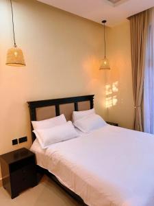 a bedroom with a white bed with two pillows at Cozynest nungwi in Nungwi
