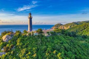 a lighthouse on a hill next to the ocean at Yen Phu Hotel Tuy Hòa in Tuy Hoa