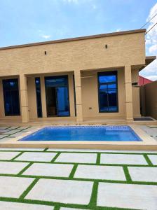 a swimming pool in front of a house at Cozynest nungwi in Nungwi