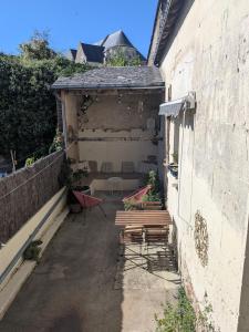 a patio with two benches on the side of a building at Maison Familiale in Reugny