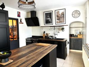 a kitchen with black cabinets and a wooden counter top at Maison Familiale in Reugny