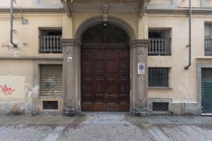 duże drewniane drzwi na boku budynku w obiekcie La tua casa nel Quadrilatero w Turynie