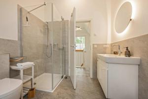 a bathroom with a shower and a toilet and a sink at Fischerdorf Ferienhaus JoHann in Zirchow +33 photos