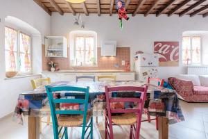 een keuken met een tafel met kleurrijke stoelen bij La tua casa nel Quadrilatero in Turijn