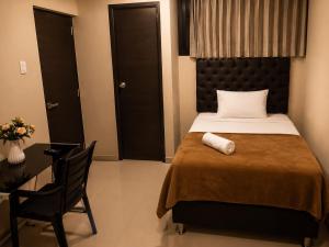 a bedroom with a bed and a desk and a chair at HOTEL SAN GABRIEL cerca AL CENTRO DE CHICLAYO in Chiclayo