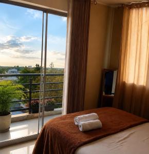 a bedroom with a bed and a large window at HOTEL SAN GABRIEL cerca AL CENTRO DE CHICLAYO in Chiclayo